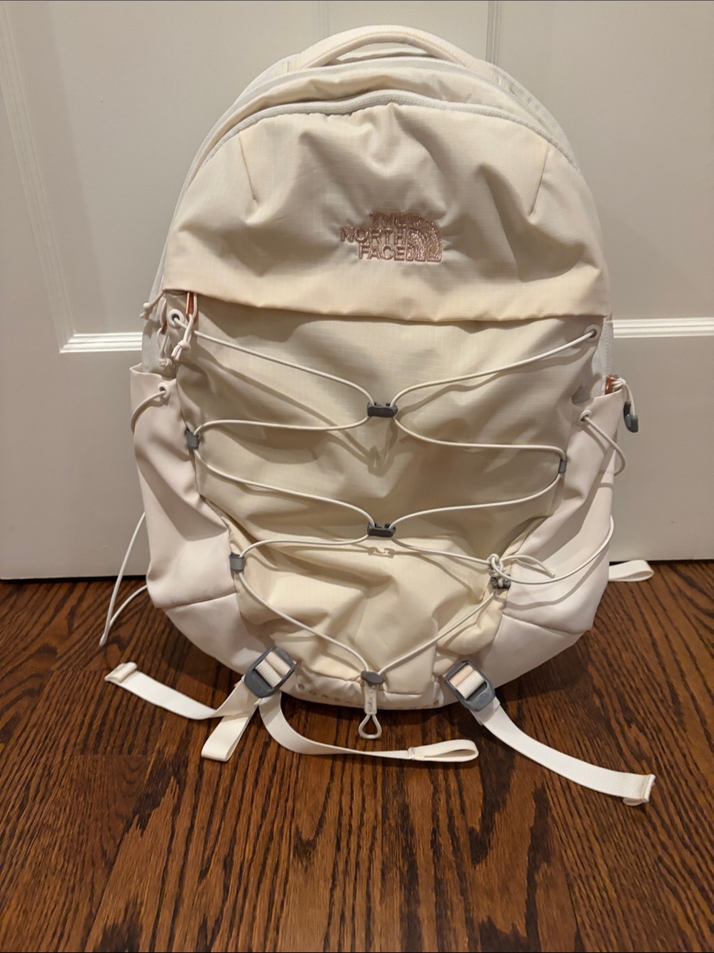 The North Face Cream backpack rose gold writing